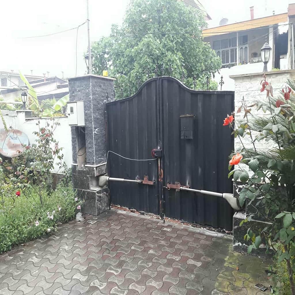 بازوی جک درب پارکینگ مشکی بر درب دولنگه سفید