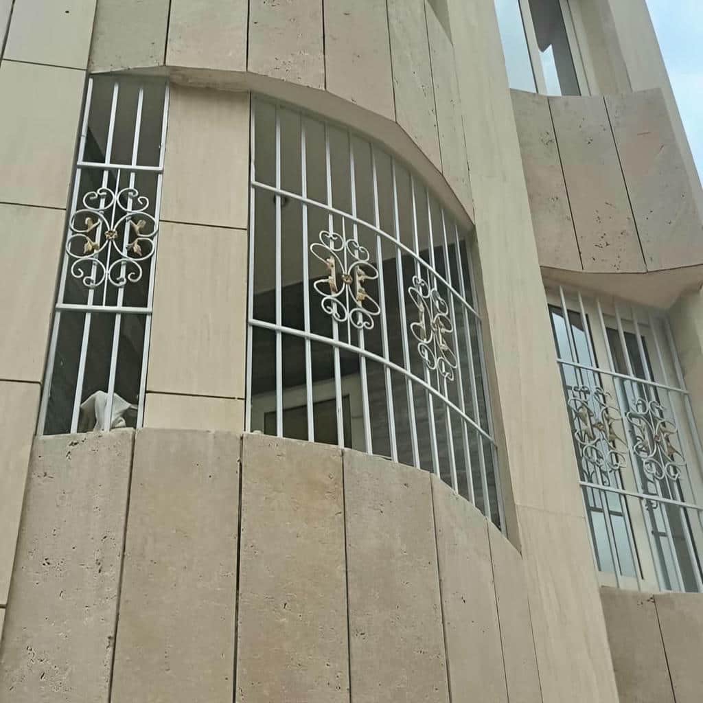 نرده فلزی سفید روی نمای سنگی ویلا