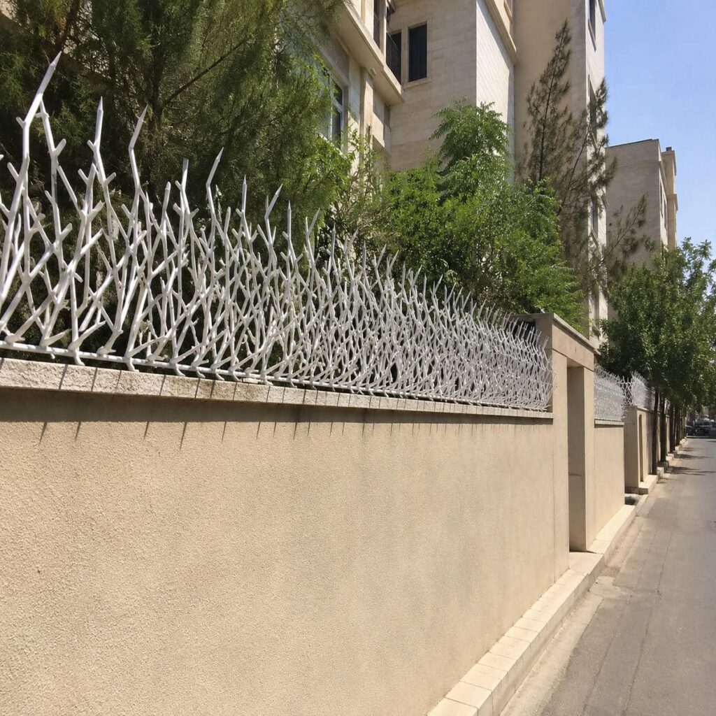 نمای نزدیک شاخه‌های متراکم نرده آهنی مشکی